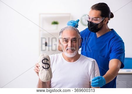 Old man visiting young male doctor in hair transplantation conce