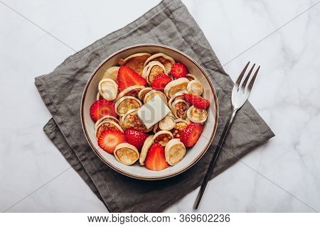 Trendy Home Breakfast With Tiny Cereal Pancakes With Piece Of Butter And Fresh Strawberries In The B