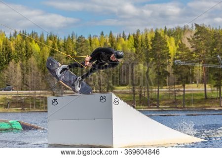 Fagersta, Sweden - Maj 26, 2020: Wakeboarder Flies In The Air On Wakeboard. Wakeboarding Is Extreme 