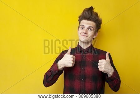 Guy With A Funny Hairstyle Shows Likes And Smiles On A Yellow Isolated Background, Confident Man Wit