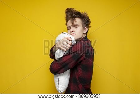 Sleepy Sad Guy Hugs A Pillow On A Yellow Isolated Background In The Morning, Hipster With A Funny Ha