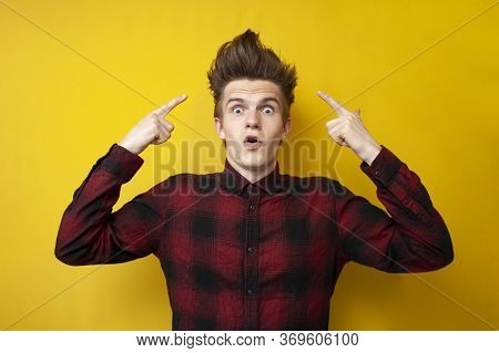 Surprised Guy Shows His Funny Hairstyle On A Yellow Isolated Background, Shocked Man With Strong Hai