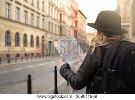 Young Girl Is Looking At A City Map On The Street On A Journey.