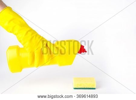Hands In Rubber Gloves Holding A Plastic Bottle With Detergent And A Sponge.