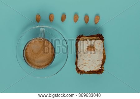 A Glass Cup Of Black Coffee With Merinque Cake And Almond. Top View.