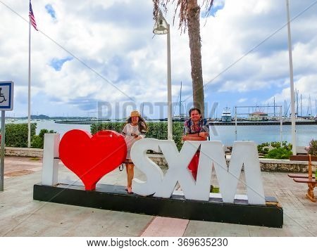 Marigot, Sint Maarten - May 14, 2016: The Couple Posing Near Sign And Statue I Love St Martin In Mar