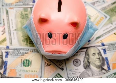 Piggy Bank In A Mask On A Background Of American Currency.the Concept Of Coronavrius Epidemic