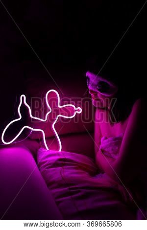 A Beautiful Girl Is Sleeping In A Sleep Blindfold With A Purple Neon Sign Dog. Good Night. Trendy St