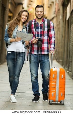 Positive Couple In Casual Clothes With Trunk And Backpack Outdoor