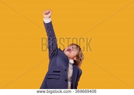 The Screaming Happy Boy Raised His Hand Up, In A Gray Jacket.