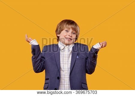 Smiling Boy Spread His Hands To The Sides And Asks A Question