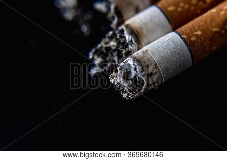 Cigarette Butt On A Dark Black Background