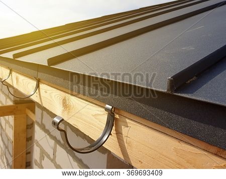 Close Up View Of Folded Roof Of House Under Construction With Holders For Gutters Water Drainage Sys
