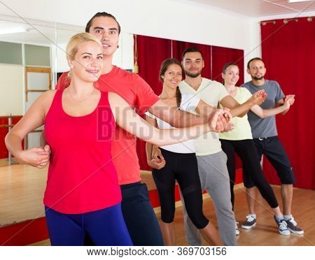 Smiling Young Adults Dancing Salsa In Club.