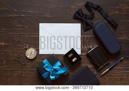 A Gift For A Man With A Blue Ribbon And Stylish Accessories Around The Card On A Dark Wooden Backgro