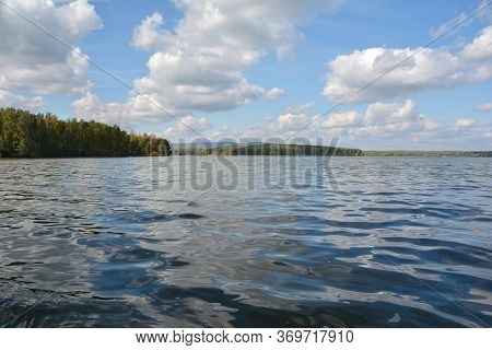 forest lake blue sky white clouds sunny day