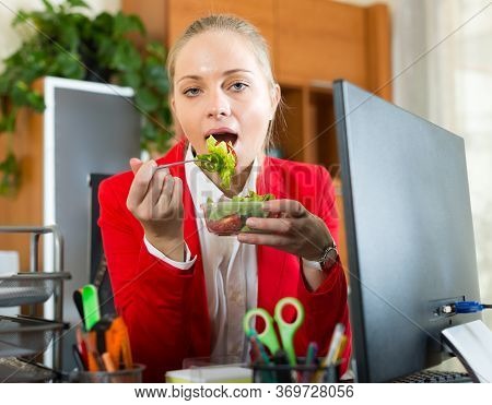 Young Blonde Businesswoman Having Healthy Lunch At Office Desk.