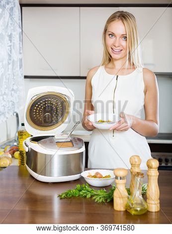Young Girl Cooking Fish Soup With Salmon And Electric Multicooker At Home