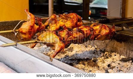 Rotisserie Of The Lechon Manok Or Roasted Marinated Chicken Cooking Over Burning Coals Is Popular Fi