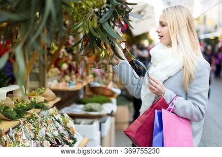 Beautiful Good Looking Woman Buying Eucalyptus At A Christmas Market