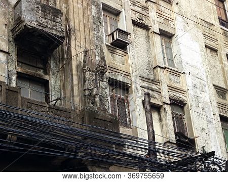 Facade Of An Old Dilapidated Building And Numerous Cables In Chinatown In Binondo District, Manila, 