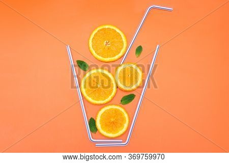 Creative Flat Lay Composition Made Of Orange Slices, Fresh Mint Leaves And Cocktail Straws On A Brig