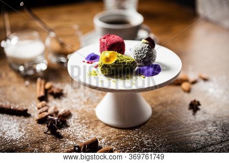 Vegan truffles dessert made of dates, almound and peanut butter on a plate. Delicious healthy food closeup served for lunch on a table in modern gourmet cuisine restaurant.