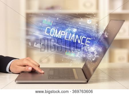 Closeup of businessman hands working on laptop with COMPLIANCE inscription, succesfull business concept