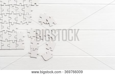 Pieces of empty jigsaw puzzle on white table
