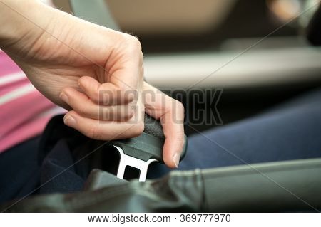 Close Up Of Woman Hand Fastening Seat Belt While Sitting Inside A Car For Safety Before Driving On T