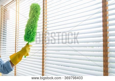 Young Female Spring Cleaning House Interior Holding A Duster For Wiping Dust Dusting Furniture At Ho