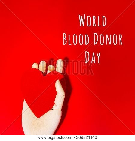 Wooden Hand With Big Red Heart In A Giving Gesture. World Blood Donor Day Wording. Donation, Help, H