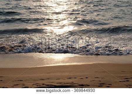 CANDOLIM, INDIA - FEBRUARY 18, 2020: Wave rolling over the sands on Candolim Beach, North Goa, India