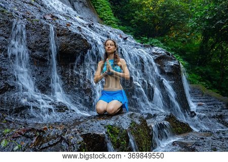 Yoga Pose. Young Caucasian Woman Sitting On The Rock, Meditating, Practicing Yoga At Waterfall. Vajr