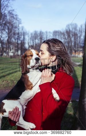 Pretty Young Girl In Redd Coat Playing With Dog Outside In Green Park, Lifestyle People Concept