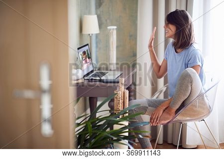 Young sexy woman having a pleasant video call in light room