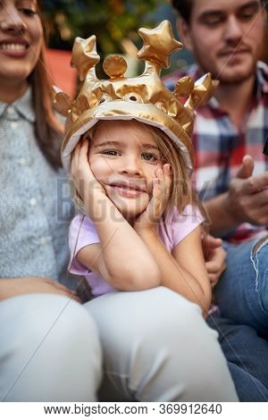 Cute birthaday girl with crown celebrating birthday in family