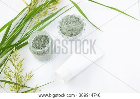 Green Cosmetic Clay For Skin And Hair In A Glass Jar On A White Background. White Tube Mockup For Br