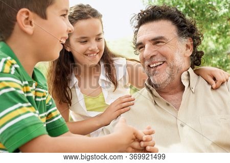 Portrait of senior man having fun having fun with grand daughter and grand son