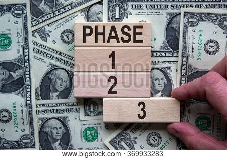 Wooden Blocks Form The Words 'phase, 1, 2, 3,' On Background From Dollar Bill. Male Hand. Beautiful 