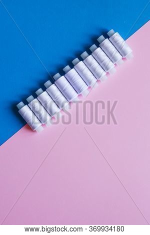 Row Of Whitethread Spools On Table Flatlay