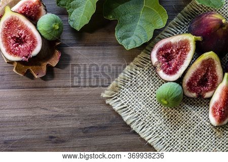 Figs, Green Leaves On Rustic Wooden Background