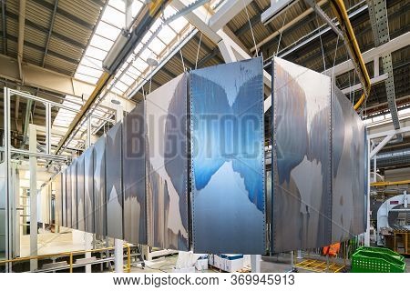 Powder Coating Line. Metal Panels Are Suspended On An Overhead Conveyor Line. Painting Products In A