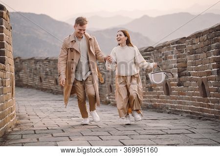Young Couple Running And Twirling At The Great Wall Of China