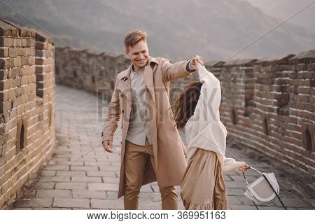Young Couple Running And Twirling At The Great Wall Of China