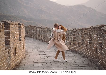Young Couple Running And Twirling At The Great Wall Of China