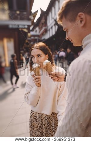 Newlywed Couple Eating Ice Cream From A Cone On A Street In Shanghai Near Yuyuan China.