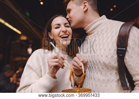 Newlywed Couple Eating Noodles With Chopsticks In Shanghai Outside A Food Market