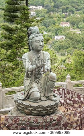 Buddhist Deva Statue Offering A Lamp To The Tian Tan Big Buddha  Statue On Lantau Island, Hong Kong