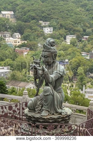 Buddhist Deva Statue Offering Ointment To The Tian Tan Big Buddha  Statue On Lantau Island, Hong Kon